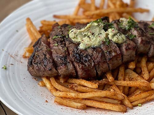Steak frites on a white plate